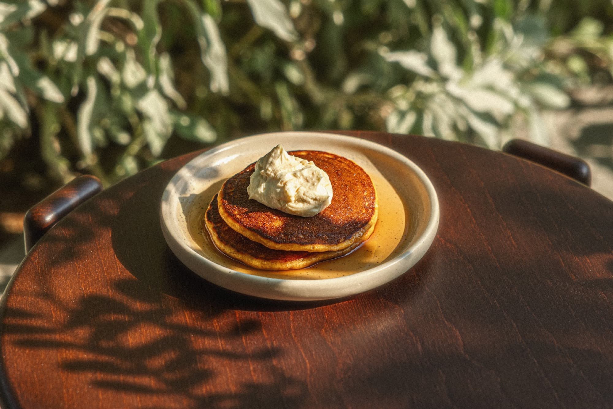 Pancakes with whipped butter in the morning sun on the terrace