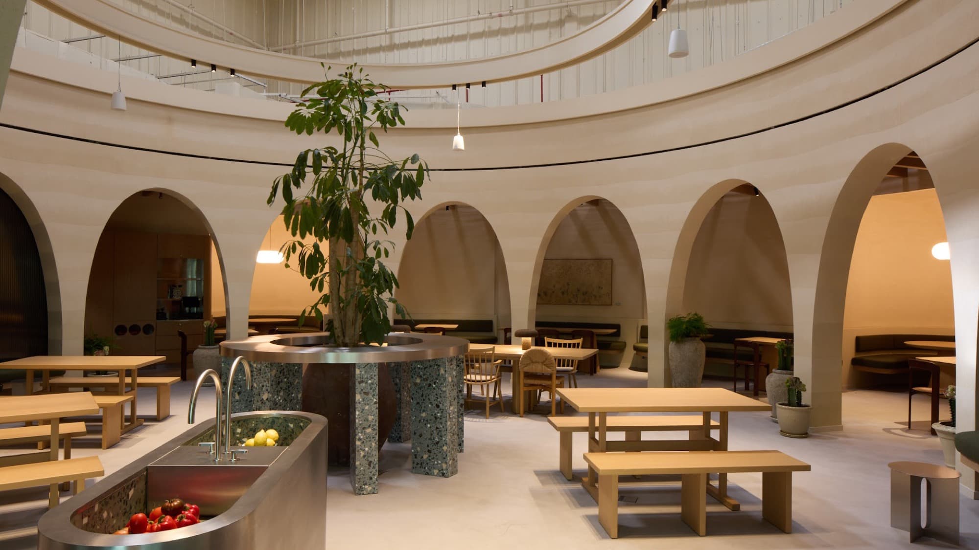 The Of The Earth rotunda — arched cream walls around a live tree at the center of the dining room